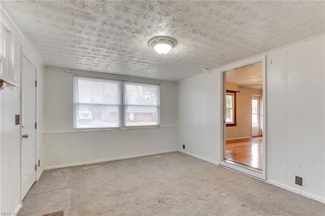 carpeted empty room featuring a textured ceiling