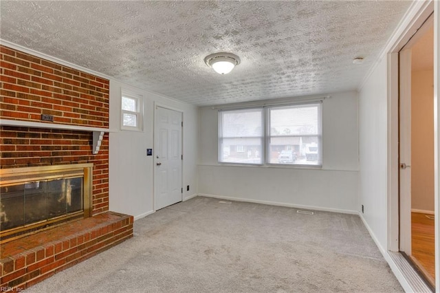 foyer featuring light carpet, a fireplace, and a textured ceiling