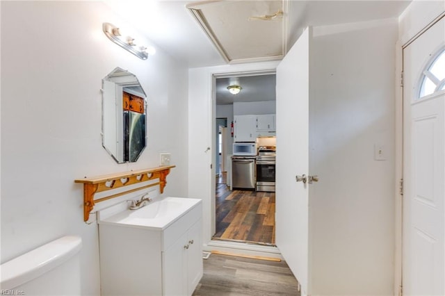 bathroom featuring vanity, wood-type flooring, and toilet