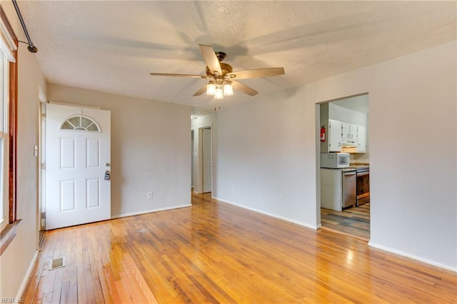 empty room featuring a textured ceiling, ceiling fan, and light hardwood / wood-style flooring