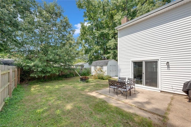 view of yard featuring a patio, a fire pit, and a storage shed