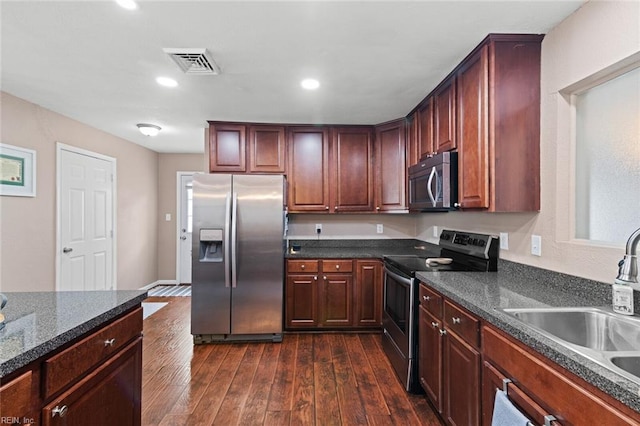 kitchen featuring appliances with stainless steel finishes, dark wood-type flooring, and sink