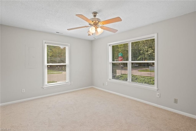 empty room featuring ceiling fan, light colored carpet, and a textured ceiling