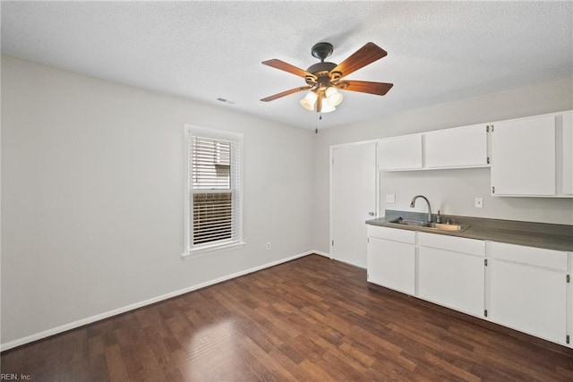 kitchen with white cabinetry, sink, ceiling fan, dark wood-type flooring, and a textured ceiling