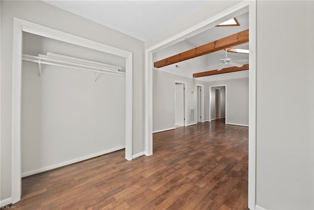 interior space with dark hardwood / wood-style flooring, lofted ceiling with beams, and a closet