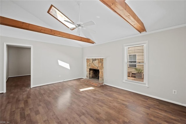 unfurnished living room featuring dark wood-type flooring, ceiling fan, a stone fireplace, and lofted ceiling with skylight