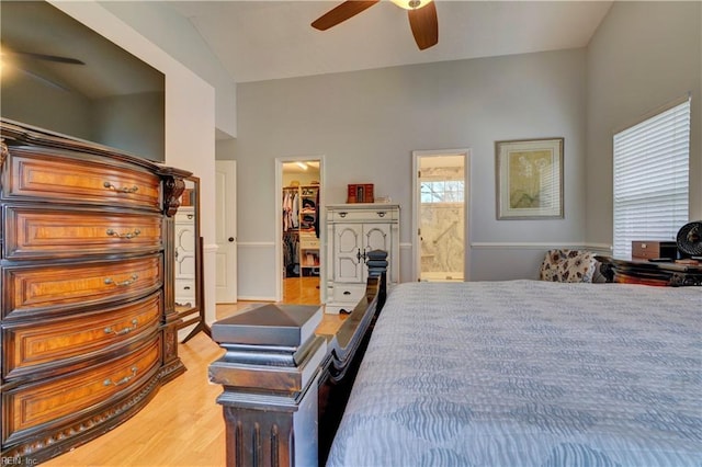 bedroom with connected bathroom, a walk in closet, ceiling fan, light wood-type flooring, and a closet