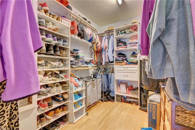 walk in closet with light hardwood / wood-style floors