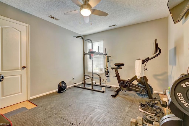 exercise area with ceiling fan and a textured ceiling