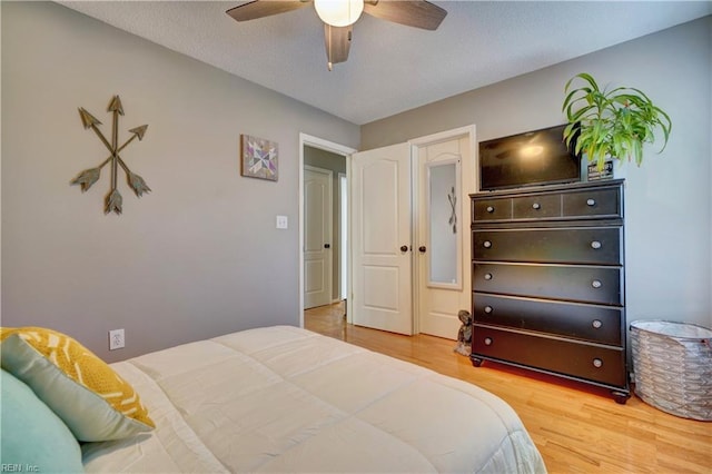 bedroom featuring hardwood / wood-style flooring, a textured ceiling, and ceiling fan