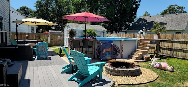 wooden deck featuring a fire pit, an outdoor bar, and a storage unit