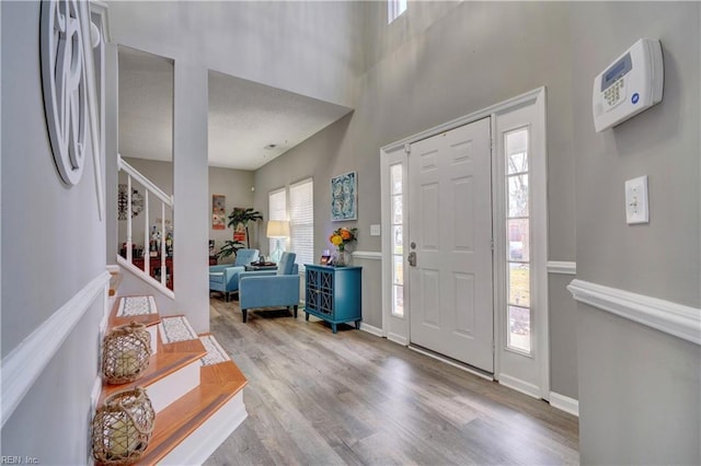 entryway with a high ceiling and light wood-type flooring