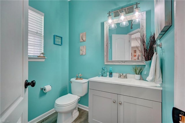 bathroom featuring vanity, wood-type flooring, and toilet