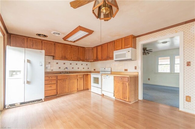 2228 Kings Hwy, Suffolk, VA 23435 - kitchen featuring a ceiling fan, a sink, white appliances, light wood-style floors, and brown cabinetry