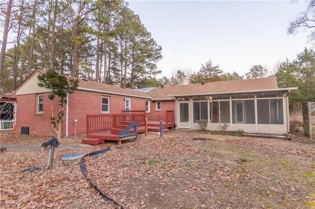 2228 Kings Hwy, Suffolk, VA 23435 - rear view of house featuring a wooden deck, brick siding, and a sunroom