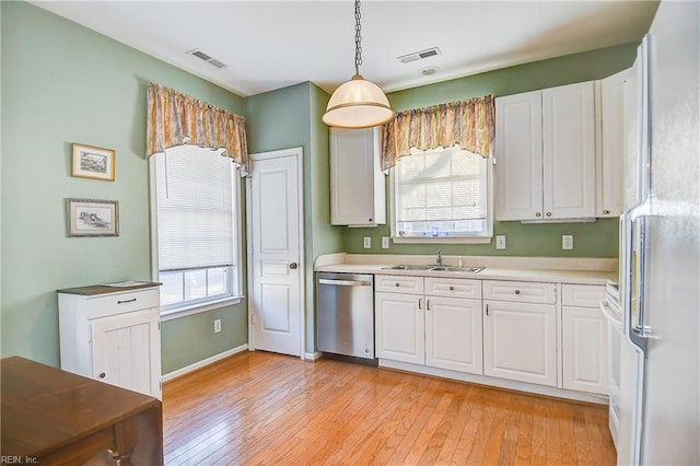 kitchen with white cabinetry, stainless steel dishwasher, sink, and hanging light fixtures