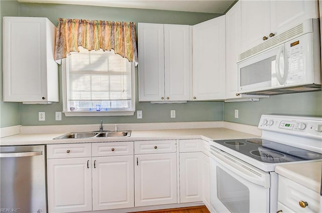 kitchen featuring white cabinetry, sink, and white appliances