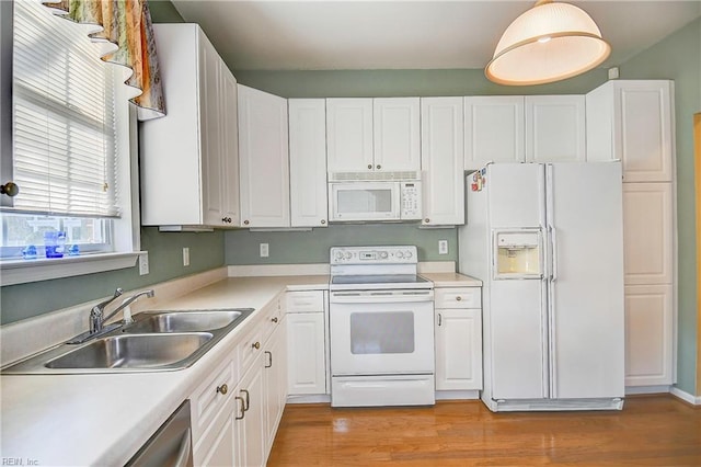 kitchen with sink, white appliances, white cabinets, and light wood-type flooring