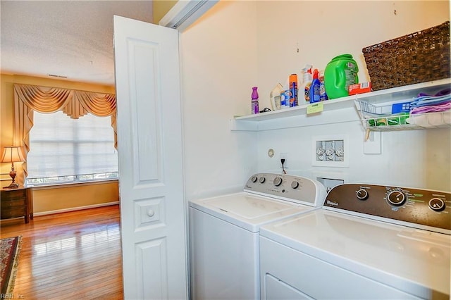 clothes washing area featuring light hardwood / wood-style floors and washing machine and dryer