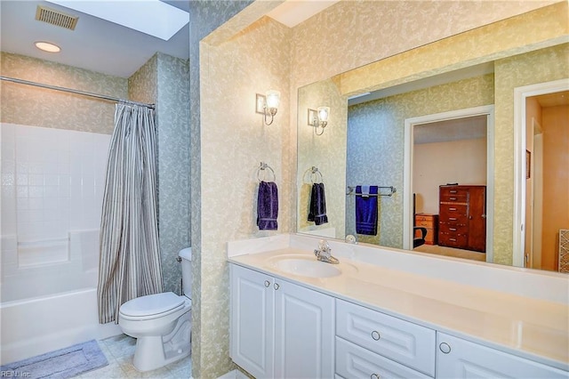 full bathroom featuring shower / tub combo with curtain, vanity, toilet, and a skylight