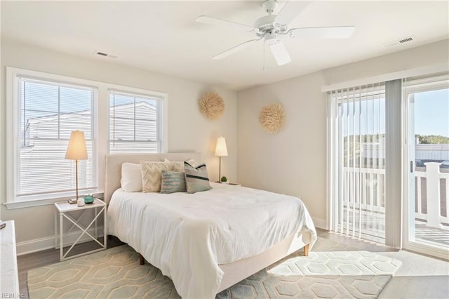 bedroom with ceiling fan, hardwood / wood-style floors, multiple windows, and access to outside