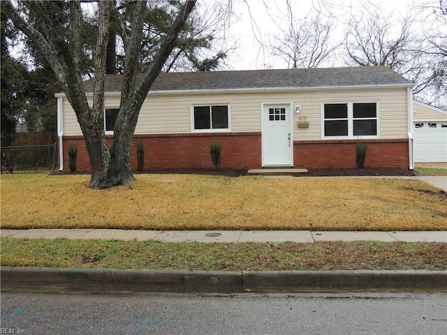 single story home featuring a garage and a front lawn