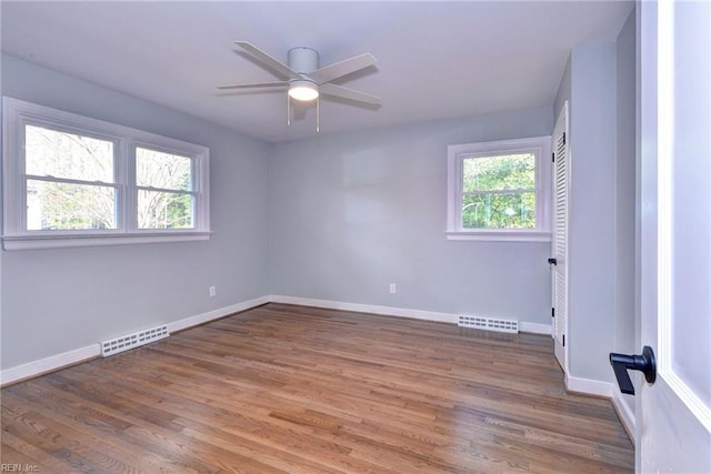 spare room with dark hardwood / wood-style flooring and ceiling fan