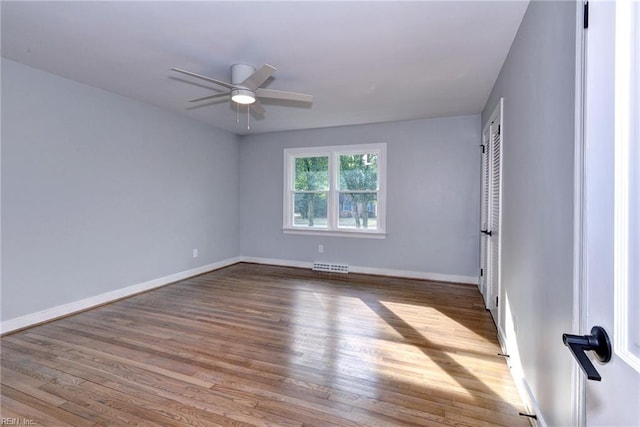 empty room with ceiling fan and light hardwood / wood-style flooring