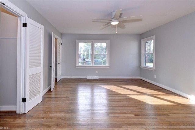 unfurnished bedroom with multiple closets, ceiling fan, and light hardwood / wood-style floors