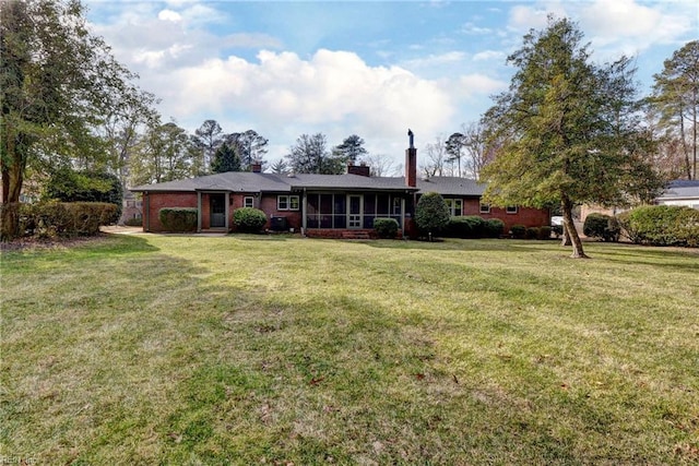 single story home featuring a sunroom and a front yard