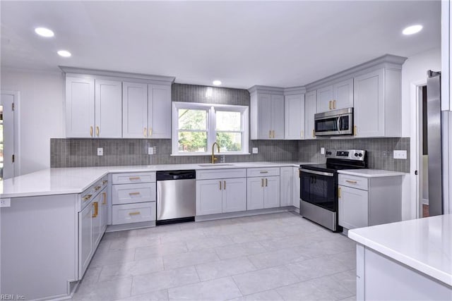 kitchen with sink, gray cabinetry, appliances with stainless steel finishes, kitchen peninsula, and backsplash