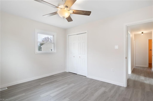 unfurnished bedroom featuring light hardwood / wood-style floors, a closet, and ceiling fan