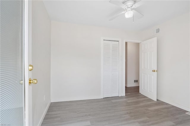 empty room with ceiling fan and light hardwood / wood-style flooring