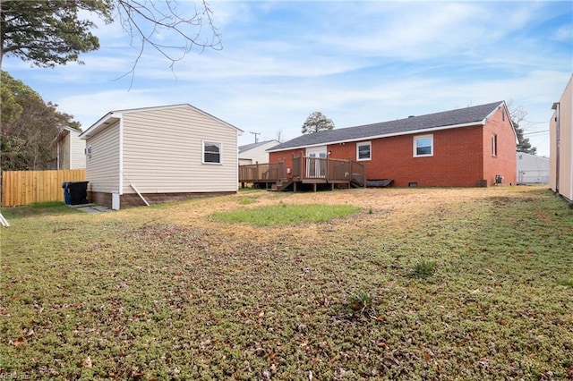 rear view of property with a wooden deck and a lawn