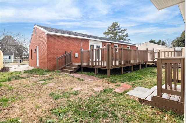 rear view of house with a lawn and a deck