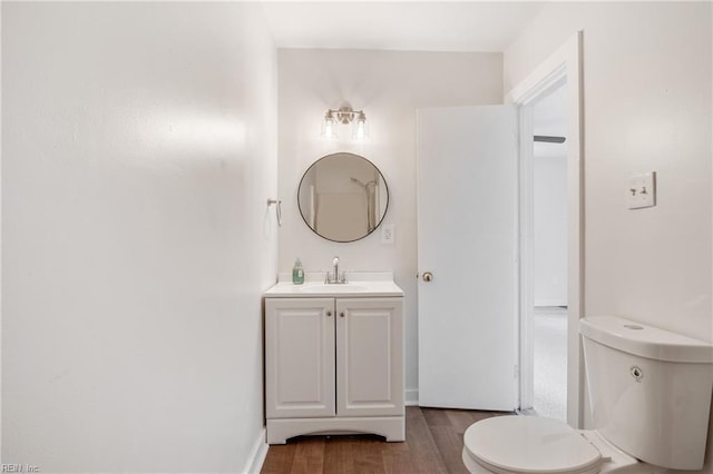 bathroom featuring vanity, hardwood / wood-style floors, and toilet