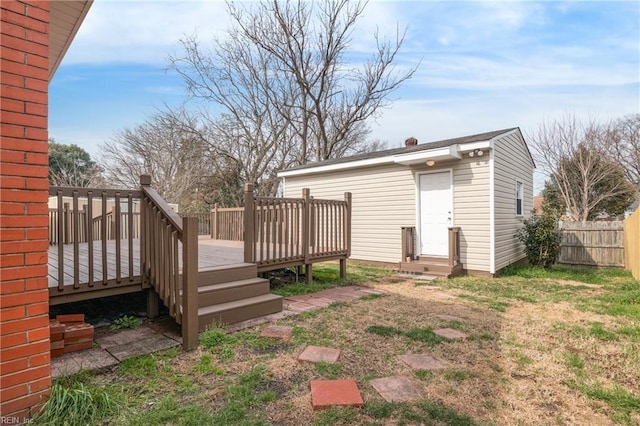 back of property featuring a wooden deck and a yard