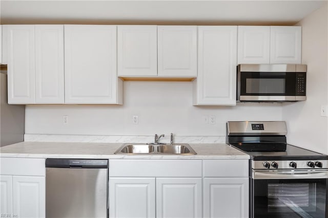 kitchen featuring appliances with stainless steel finishes, sink, and white cabinets