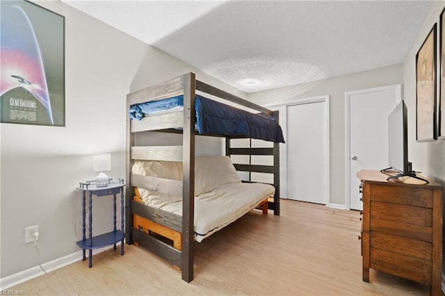 bedroom with light hardwood / wood-style floors and a textured ceiling