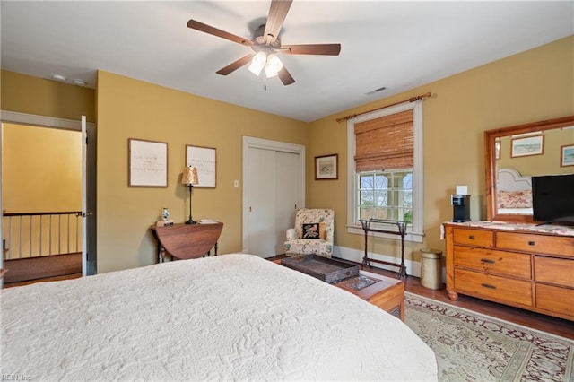 bedroom featuring dark hardwood / wood-style floors, ceiling fan, and a closet