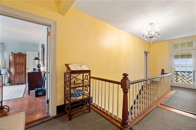 hallway with wood-type flooring and a chandelier