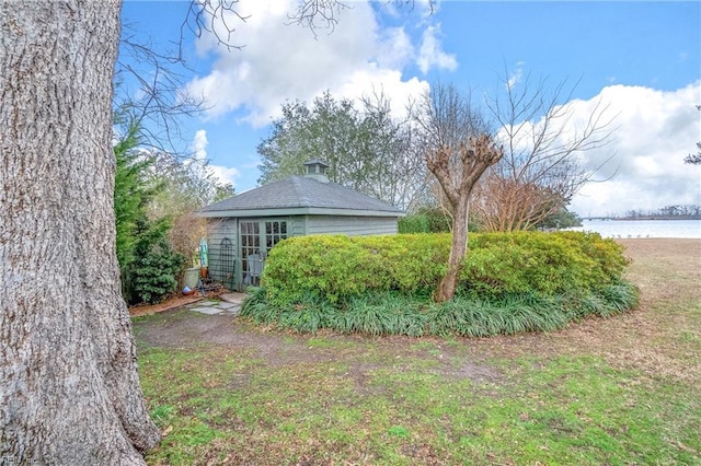 view of yard with french doors and a water view