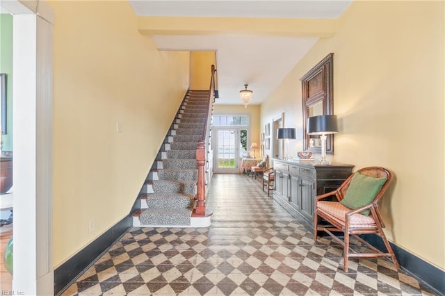 stairs featuring beamed ceiling