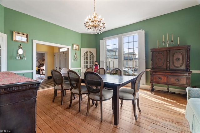 dining area featuring light hardwood / wood-style flooring and a notable chandelier