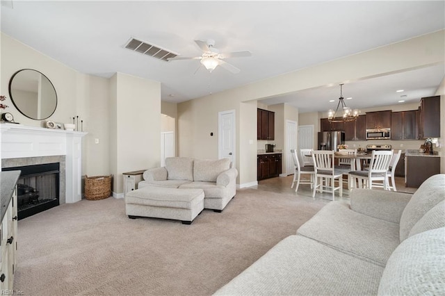2608 River Watch Dr, Suffolk, VA 23434 - carpeted living room with a tile fireplace, sink, and ceiling fan with notable chandelier