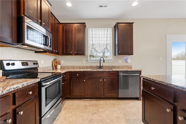 2608 River Watch Dr, Suffolk, VA 23434 - kitchen featuring light stone counters, stainless steel appliances, sink, and dark brown cabinets