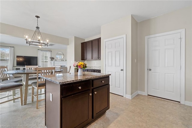 2608 River Watch Dr, Suffolk, VA 23434 - kitchen with dark brown cabinetry, a center island, hanging light fixtures, a notable chandelier, and light stone countertops