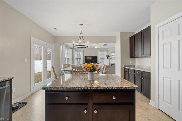2608 River Watch Dr, Suffolk, VA 23434 - kitchen with pendant lighting, a center island, light stone counters, and dark brown cabinetry