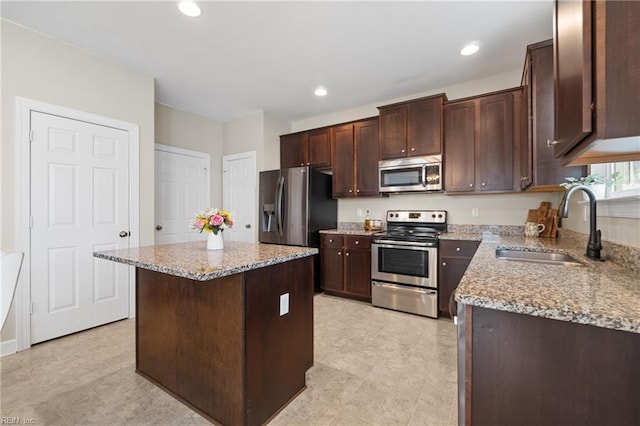 2608 River Watch Dr, Suffolk, VA 23434 - kitchen with stainless steel appliances, a kitchen island, sink, and light stone counters