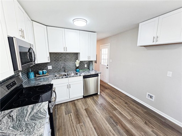 kitchen with dark wood-type flooring, sink, appliances with stainless steel finishes, light stone countertops, and white cabinets